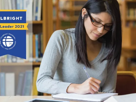 Image of student with medium length dark hair studying in a library