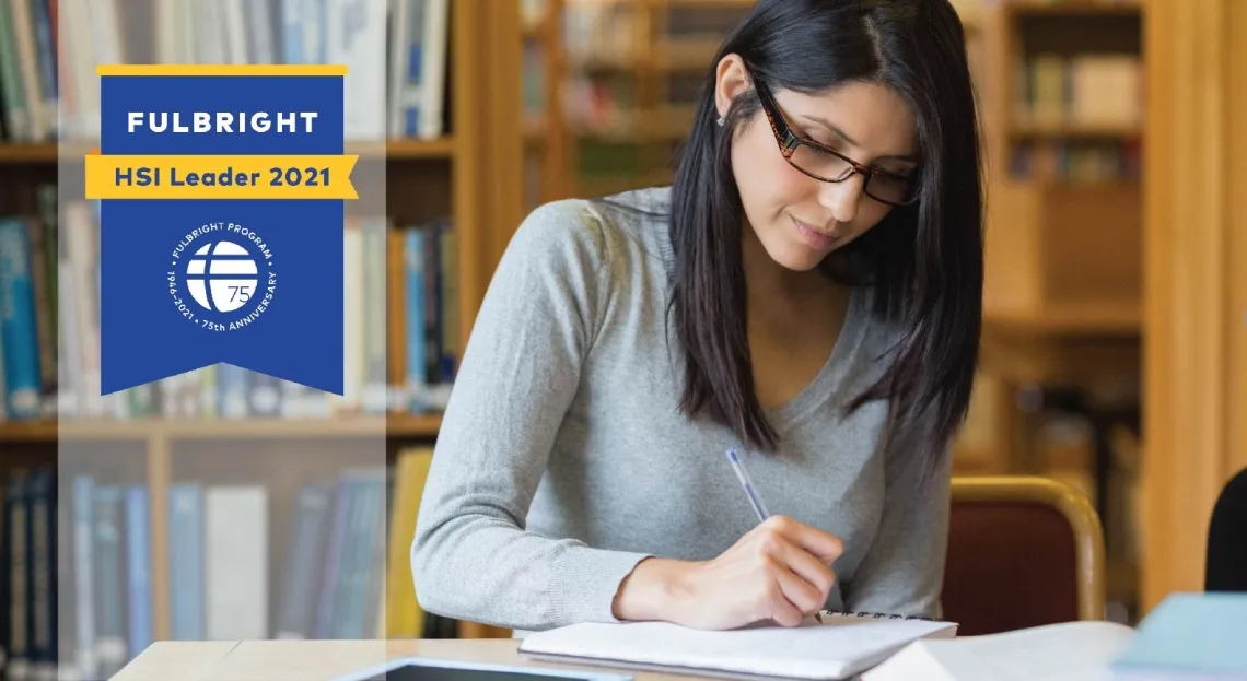 Image of student with medium length dark hair studying in a library